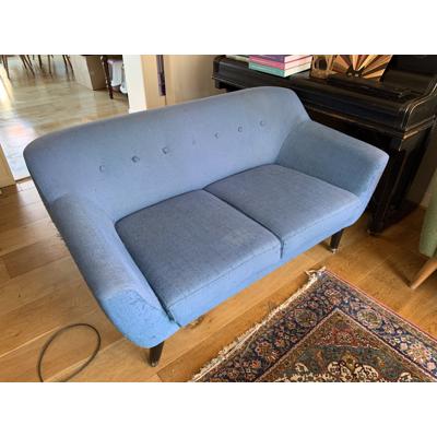 Blauwe tweezitsbank op poten retro