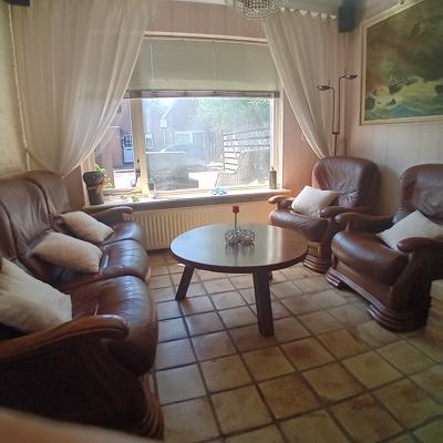Eethoek, 2 fauteuils, salontafel, eethoek + 6 stoelen met mooie rode zittingen.