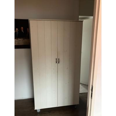 Mooie witte kinder kledingkast op wieltjes.