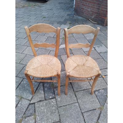 Twee houten stoelen met rieten zitting