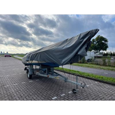 Zeilboot met trailer en buitenboordmotor