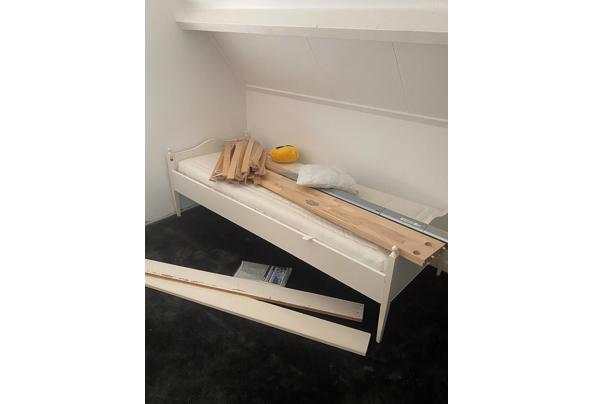 Twee ledikanten met matrassen en een boxspring - motion_photo_1881485447203692840