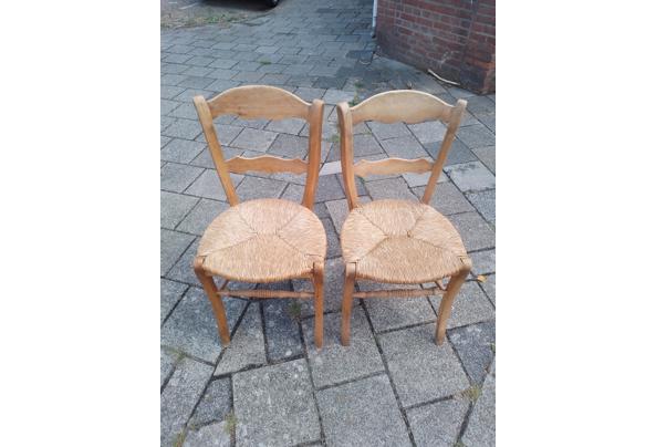 Twee houten stoelen met rieten zitting - 17869711731636250232356794269313