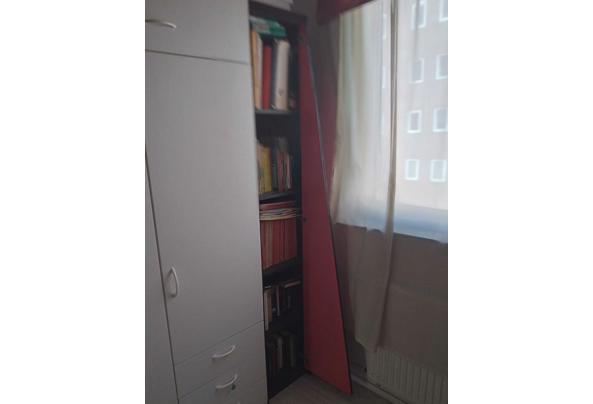 Leuk zwart houten boekenkastje met een schuine rode klapdeur. - boekenkastje