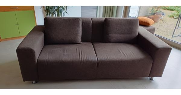 2 chocoladebruine banken en hocker stof