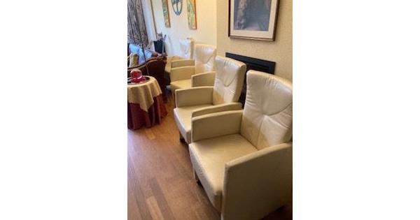 Vier crèmekleurige clubfauteultjes met wieltjes