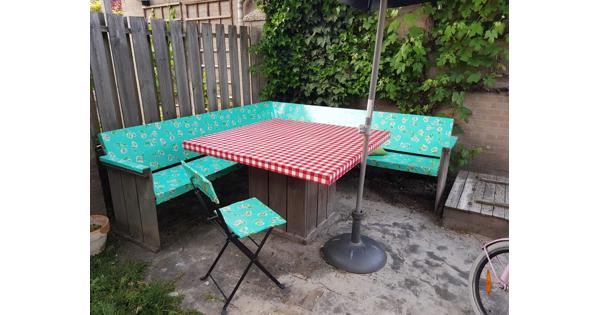 Houten tuinbank en tafel met kleurrijk zeil
