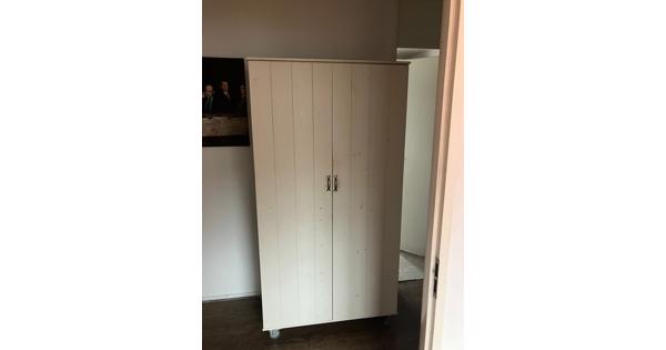 Mooie witte kinder kledingkast op wieltjes.