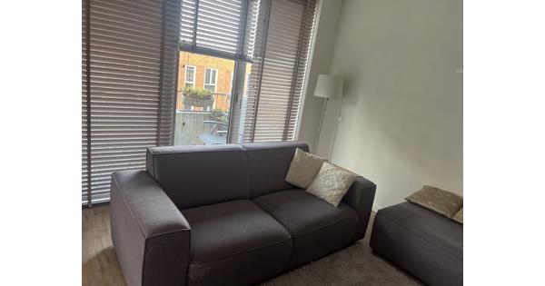 Grijze bank met poef / ottomaan