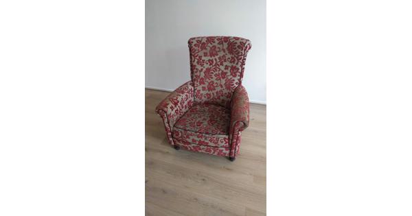 Gebruikte stoel van stof met rood en grijs bloemenpatroon