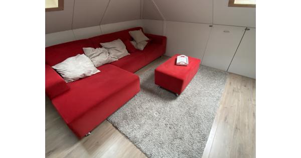 Hoek/loungebank rood plus hocker, losse sierkussens en dienblad