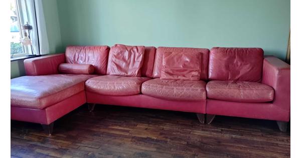Grote rode leren bank met chaise longue. Kan ook in drie losse delen worden neergezet.
