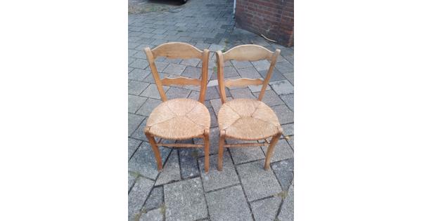 Twee houten stoelen met rieten zitting