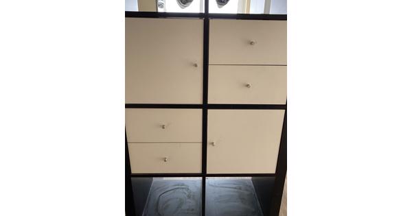 Zwart kastje met vakken, deurtjes en laatjes 