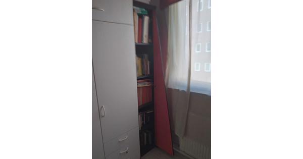 Leuk zwart houten boekenkastje met een schuine rode klapdeur.