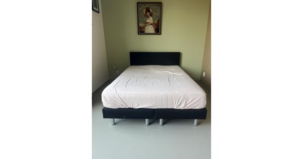 Zwart bed met achterplaat van stof