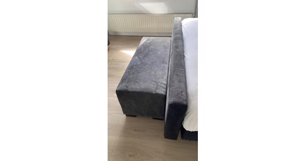 Zwart voetenbankje voor bij het bed