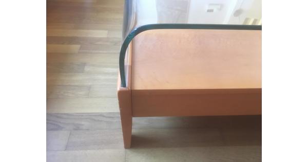 Houten salontafel met gebogen glasplaat.