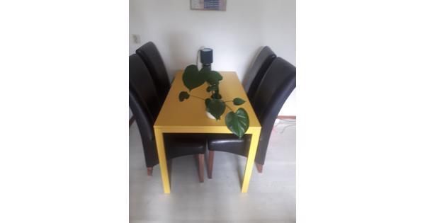 Oker gele tafel en bruine stoelen 