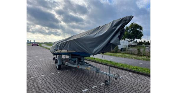 Zeilboot met trailer en buitenboordmotor